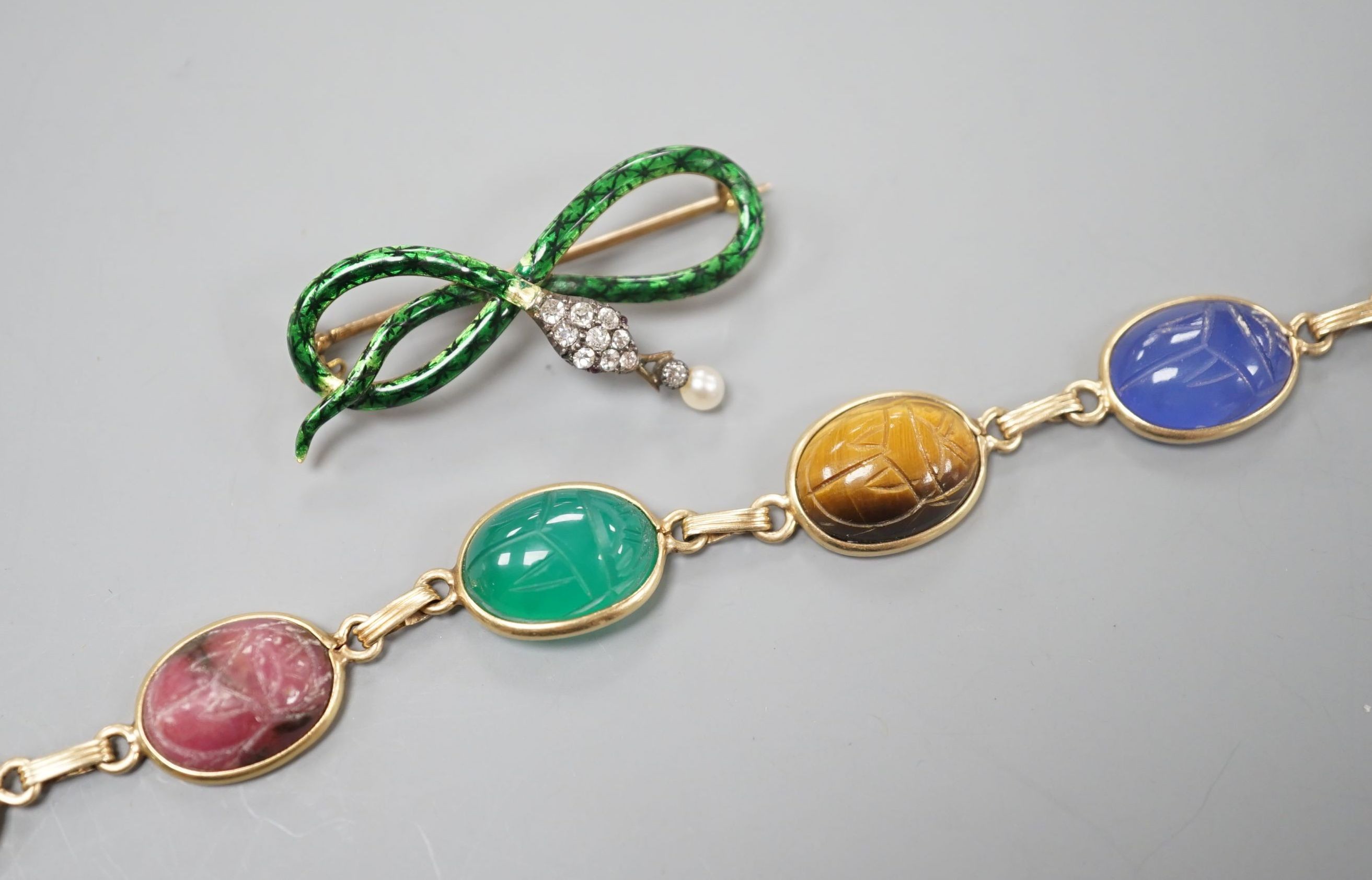 A 14k yellow metal and six stone multi gem set 'scarab' bracelet, 18.5cm, gross 15.4 grams and a yellow metal, diamond, drop pearl and green enamel set serpent brooch, gross 7.5 grams.